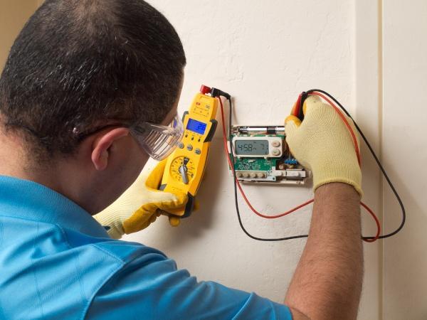 Technician performing smart thermostat installation in California