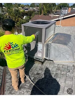 HVAC technician cleaning an outdoor air conditioning unit