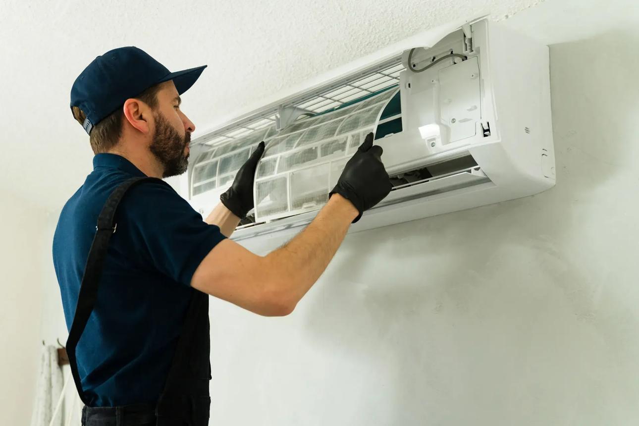 HVAC technician checking a mini-split air filter and airflow during mini split service in California
