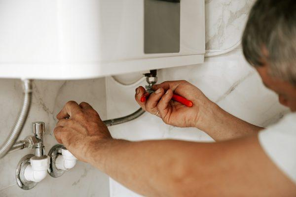 Professional installing a tankless water heater in California