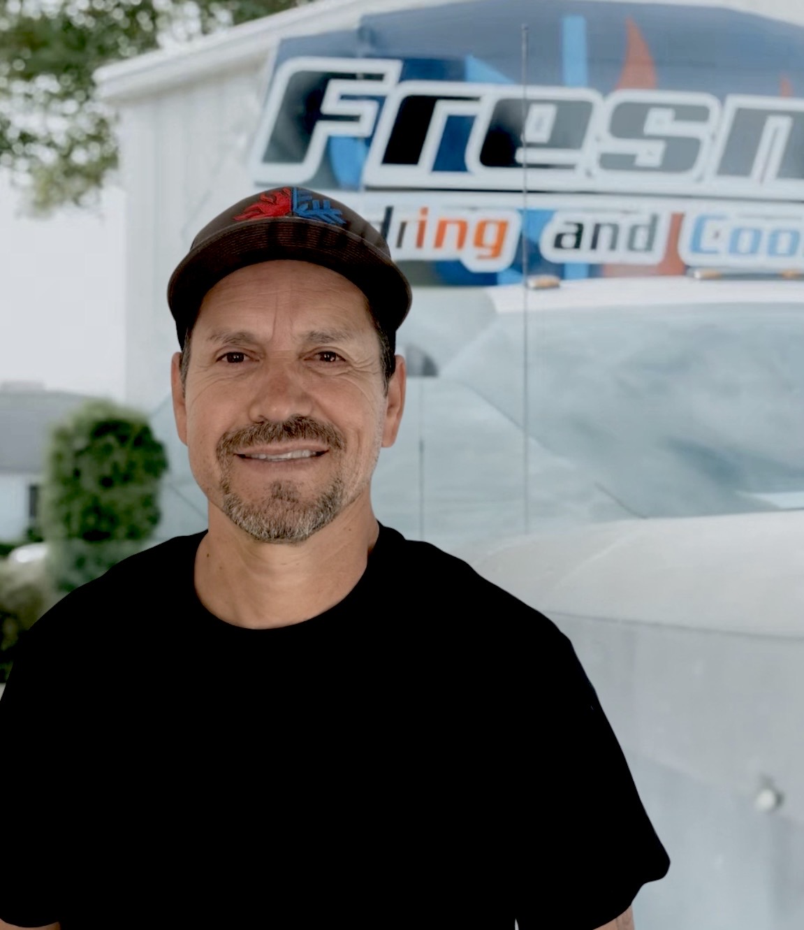 Albert Rangel, comfort specialist at Fresno Heating and Cooling, standing in front of a company service truck