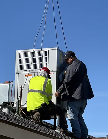 Fresno Heating and Cooling technicians installing a rooftop HVAC heat pump unit