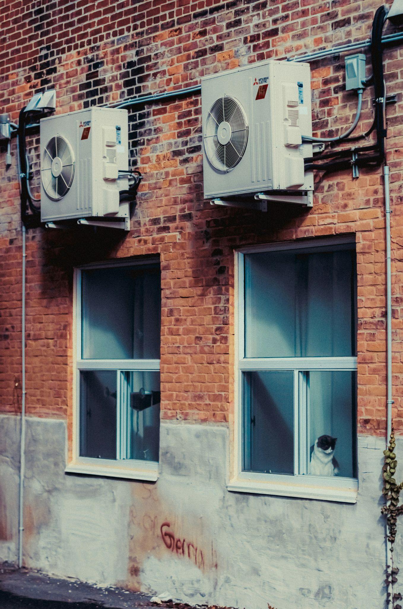 Wall-mounted outdoor AC units on a brick building illustrate commercial HVAC repair in Fresno.