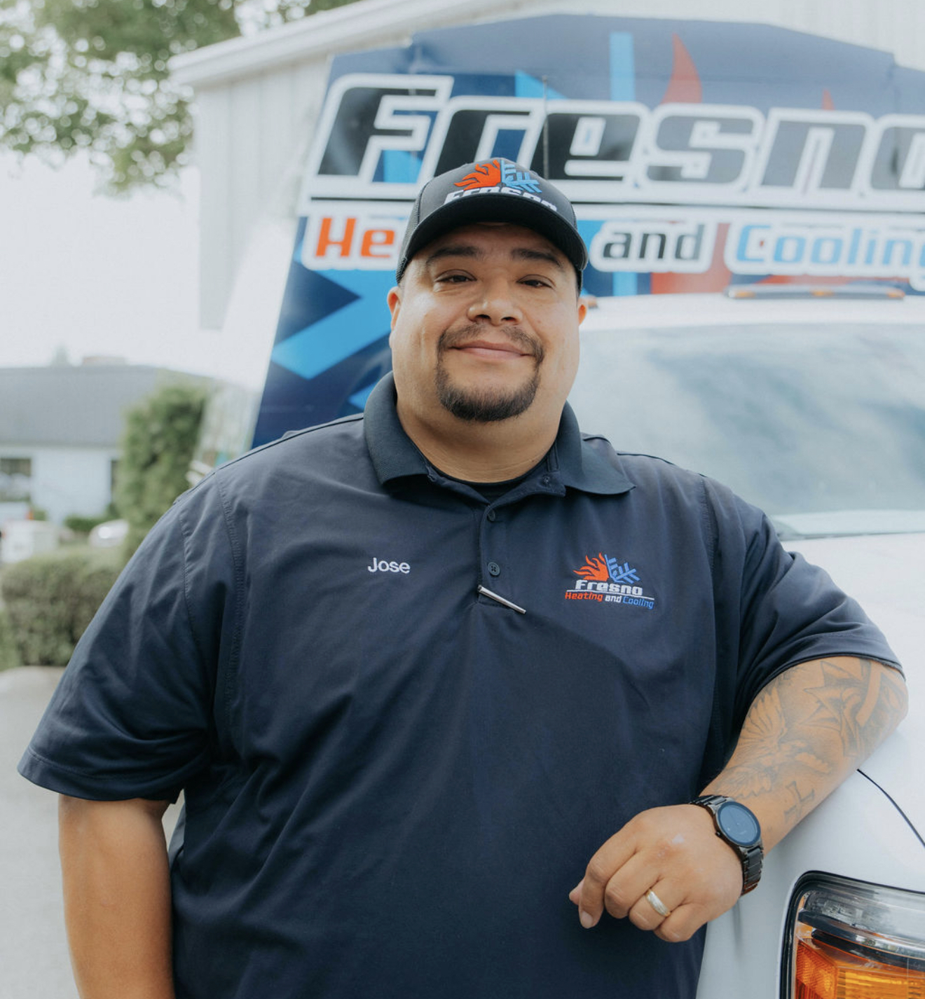 Jose Larios, proud owner of Fresno Heating and Cooling, standing in front of a company service truck