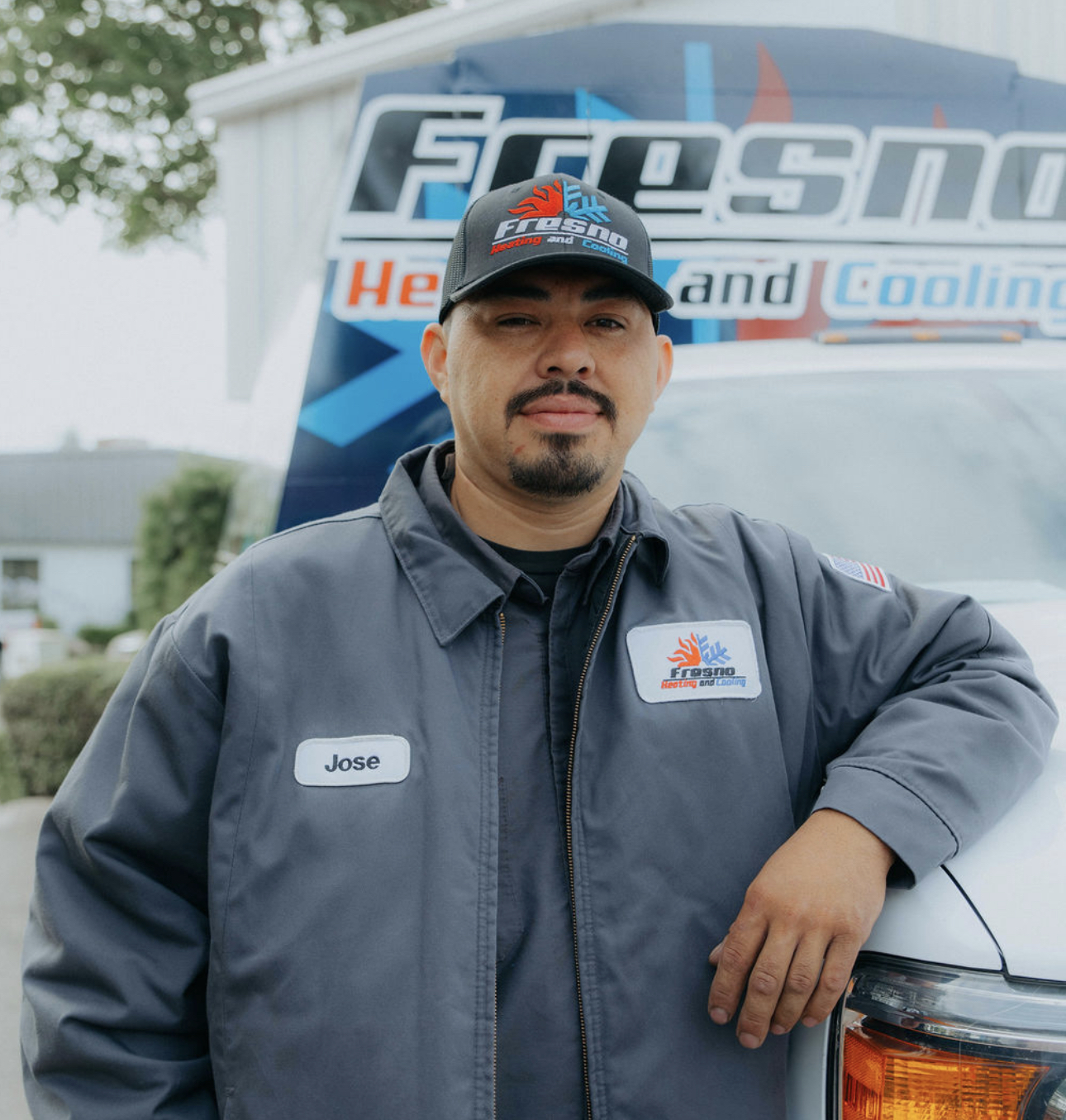 Joe, installer at Fresno Heating and Cooling, leaning against a company service truck