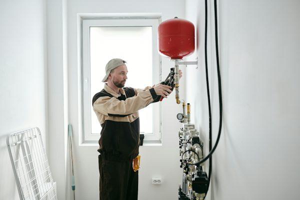 Technician servicing an electric water heater in California