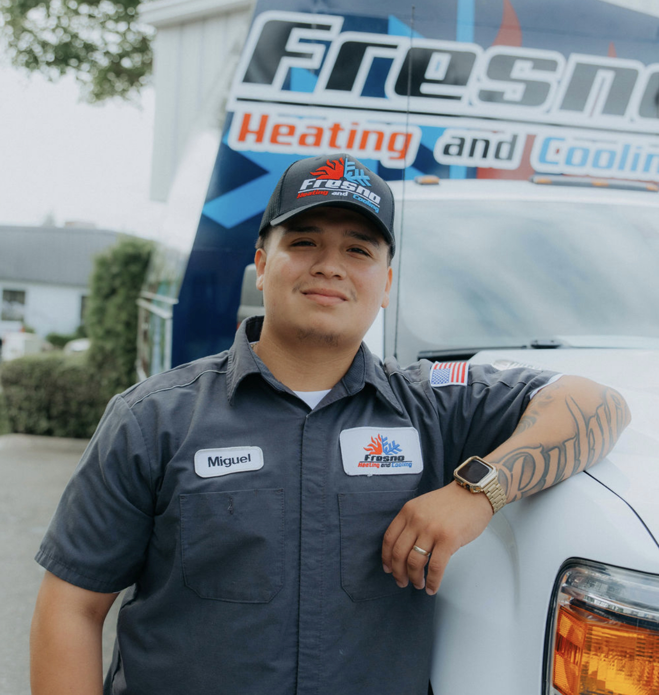 Miguel, service technician at Fresno Heating and Cooling, leaning against a company service truck