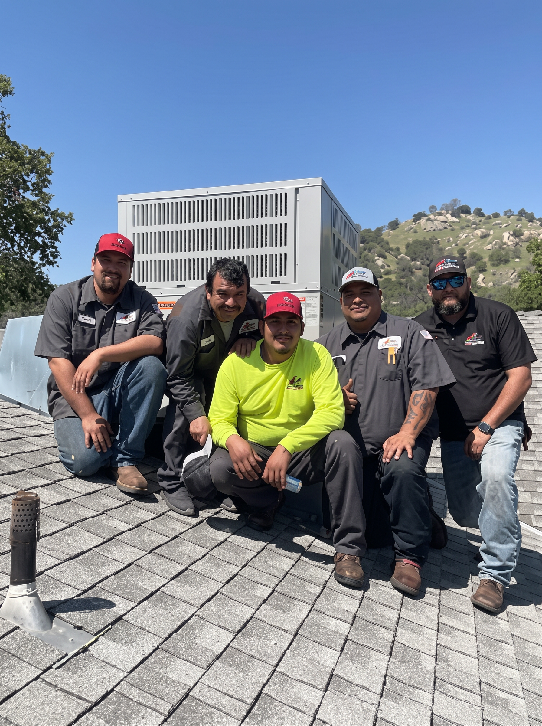 Group of Fresno Heating and Cooling technicians on a roof with an HVAC unit